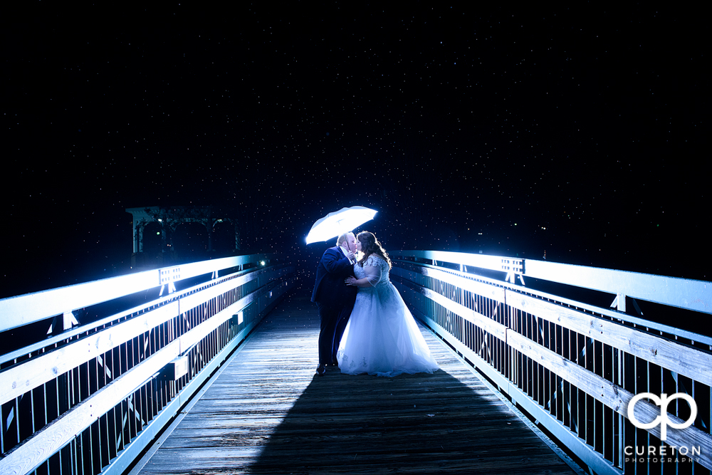 Bride and groom on a bridge in the rain during their Cleveland Park wedding reception.