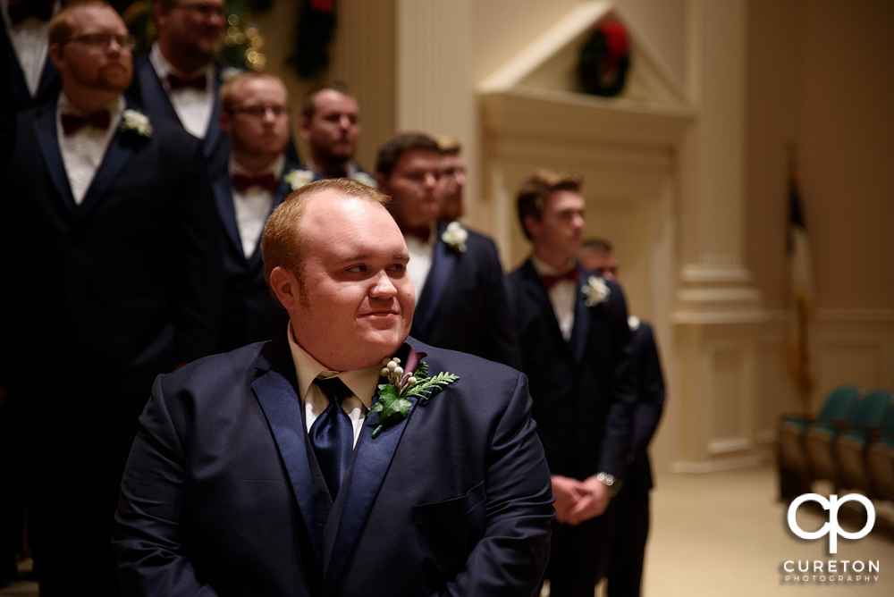 Groom sees his bride for the first time walking down the aisle.