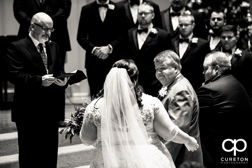 Father gives away his daughter during the ceremony.