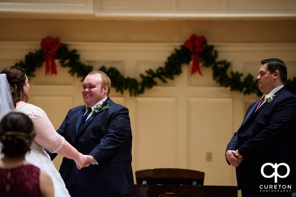 Groom smiling at his bride during the wedding ceremony.