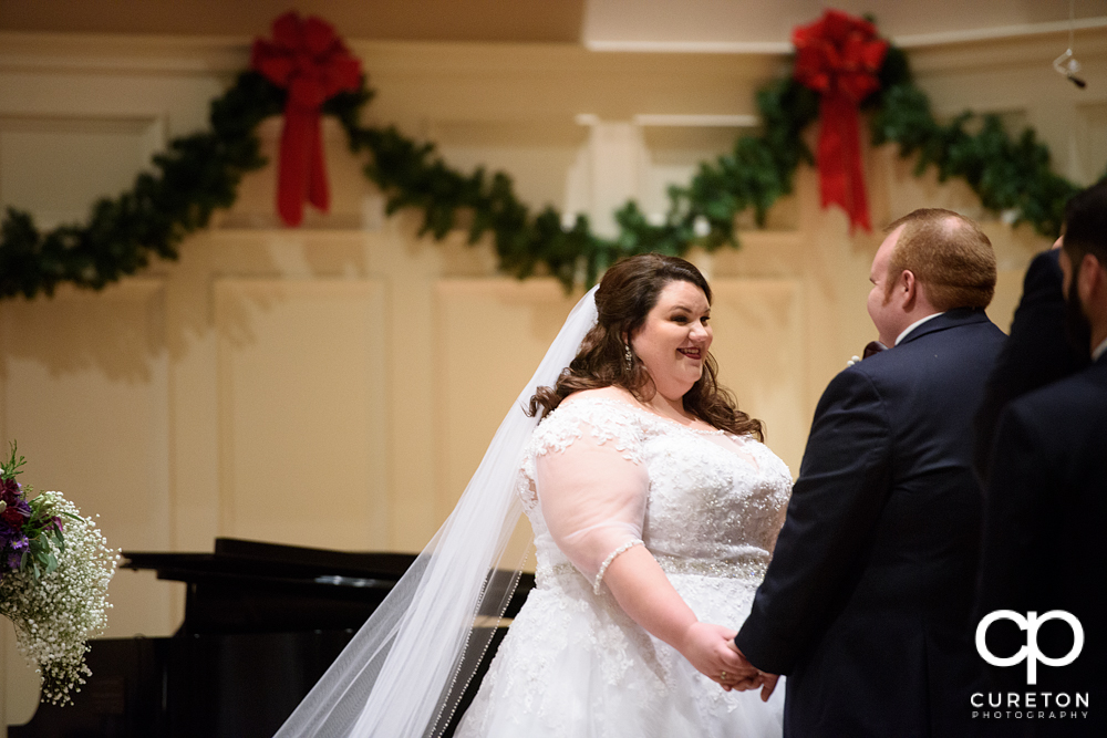 Bride smiling at her groom during the wedding ceremony.