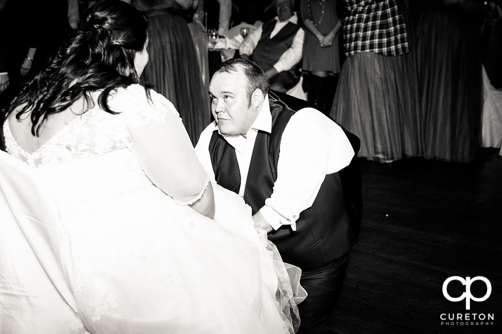 Groom taking off the garter.