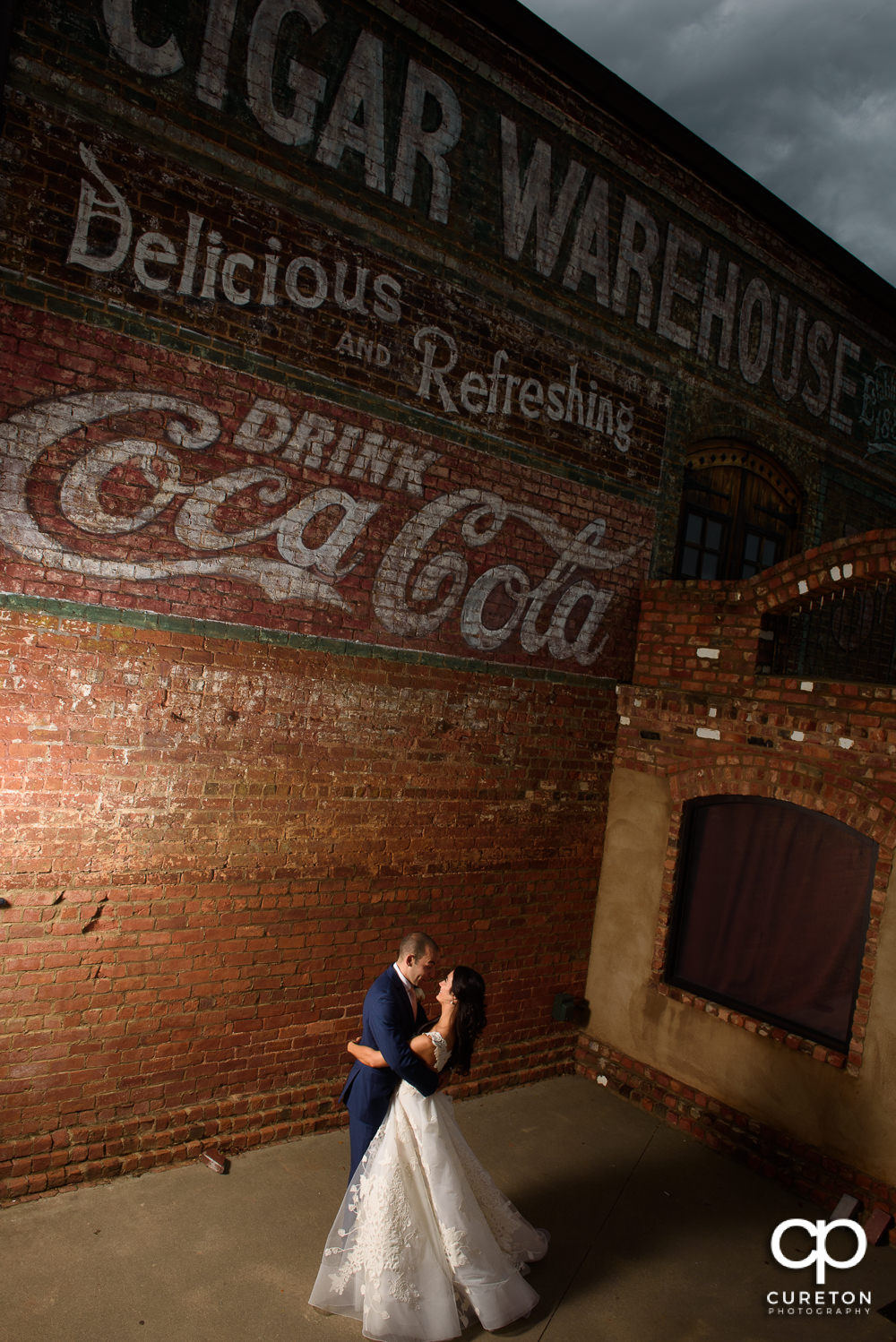 Epic photo of a bride and groom dancing under the sign at Old Cigar Warehouse.