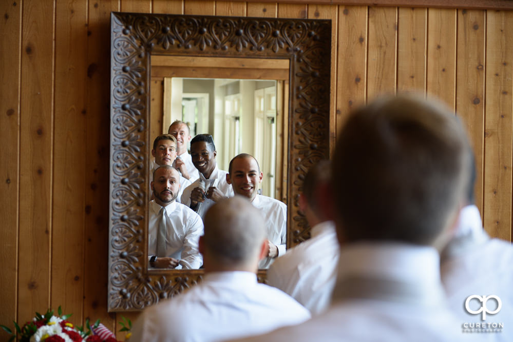 All of the groomsmen sharing a mirror getting ready.