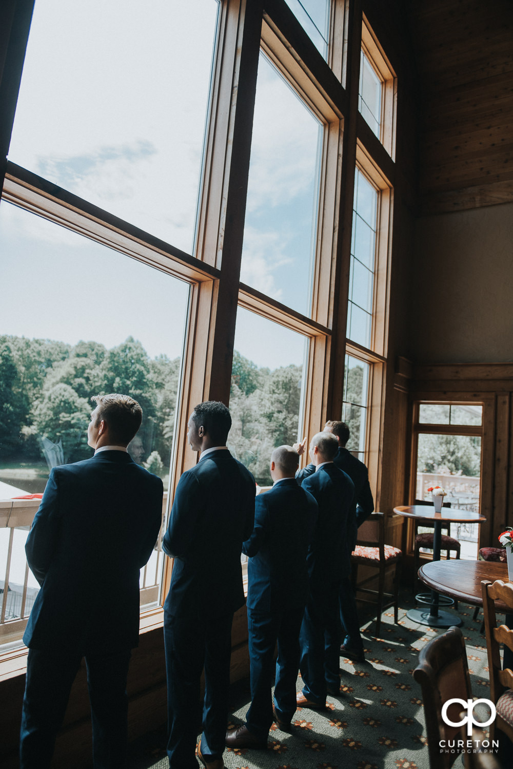 Groomsmen staring out of the window before the ceremony.