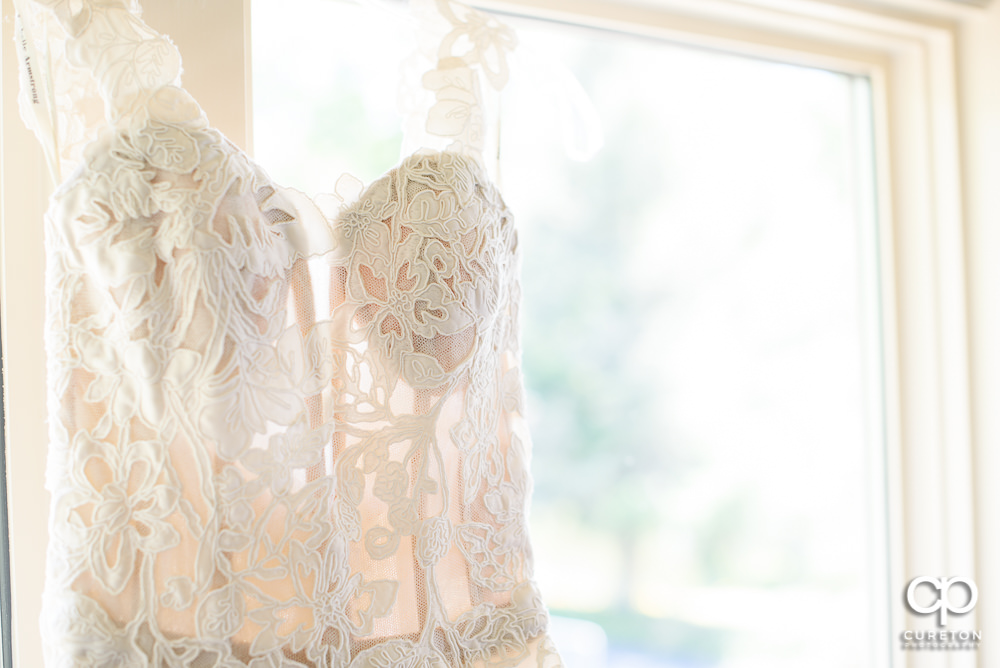Wedding dress hanging in a window close-up.