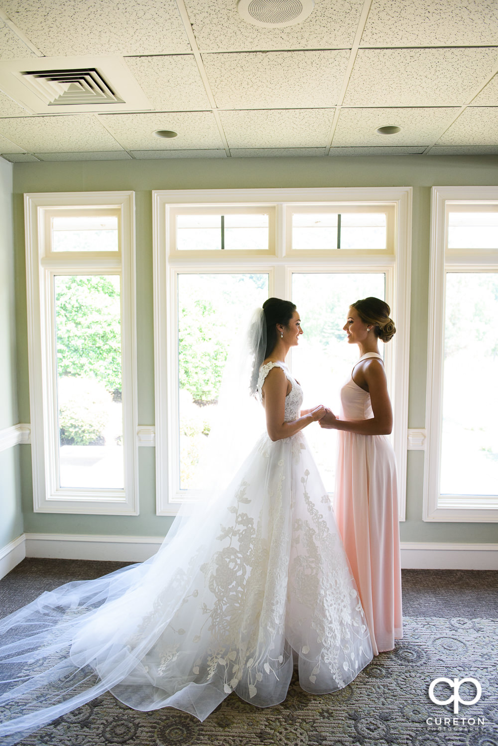 Bride and her sister holding hands.