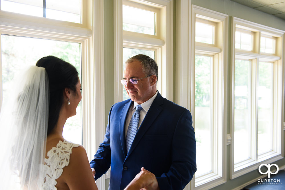 Father of the bride sees his daughter for the first time in the wedding dress.