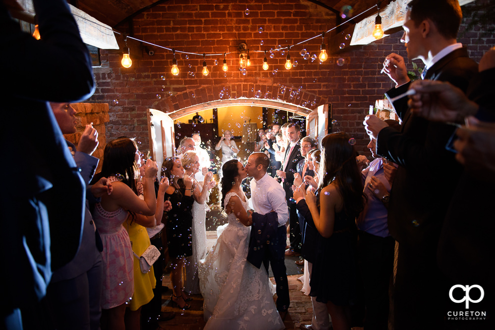 Bride and groom making a grand exit though bubbles at the Old Cigar Warehouse wedding reception.