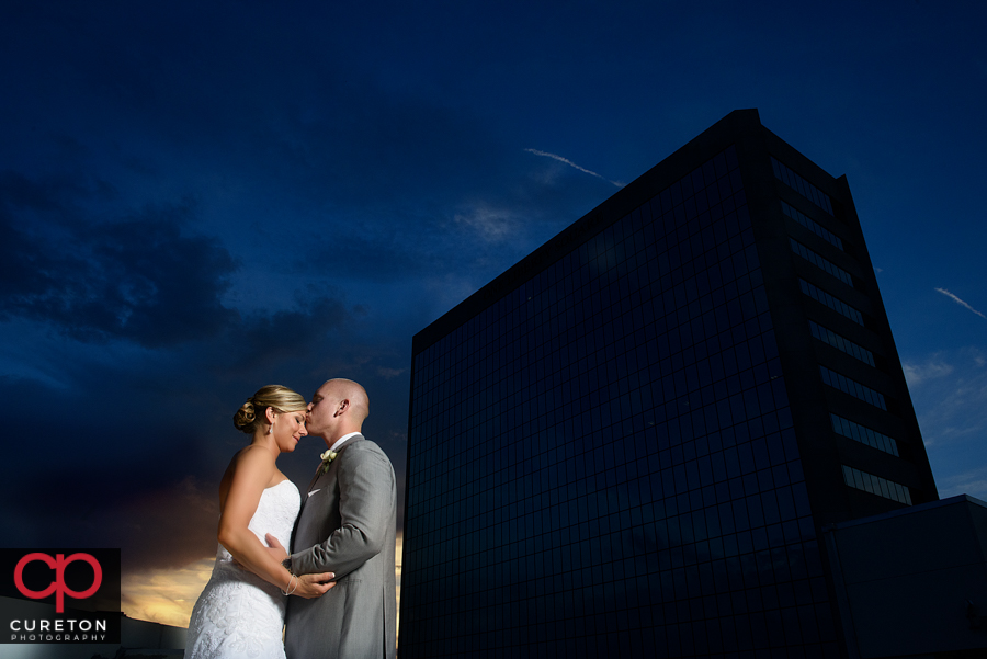 Groom kissing his brides forehead on the roof at their Commerce Club wedding. 
