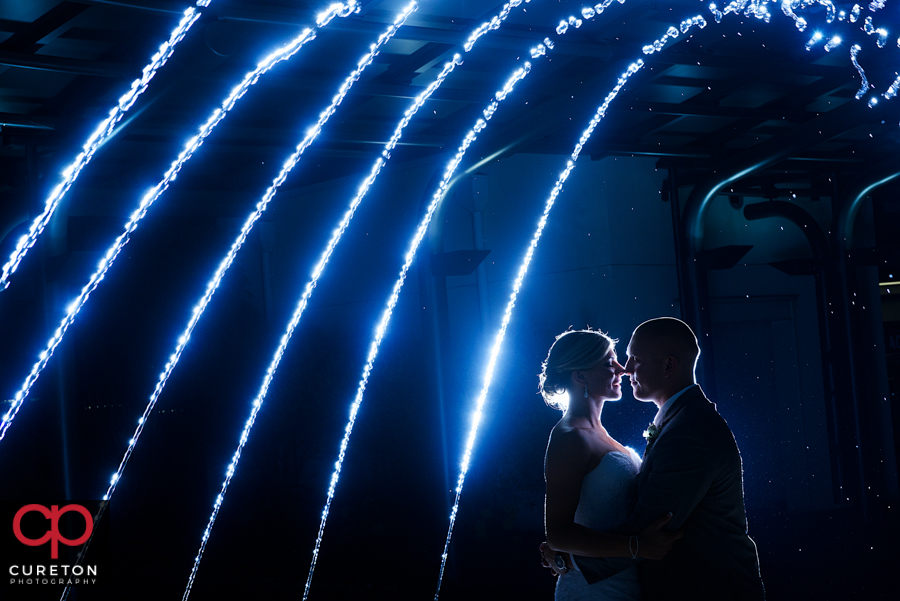 Epic shot of bride and groom in the fountains at their Commerce Club Greenville wedding. 
