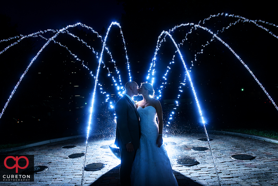 Unique photo of bride and groom after their wedding in a fountain in downtown Greenville,SC.