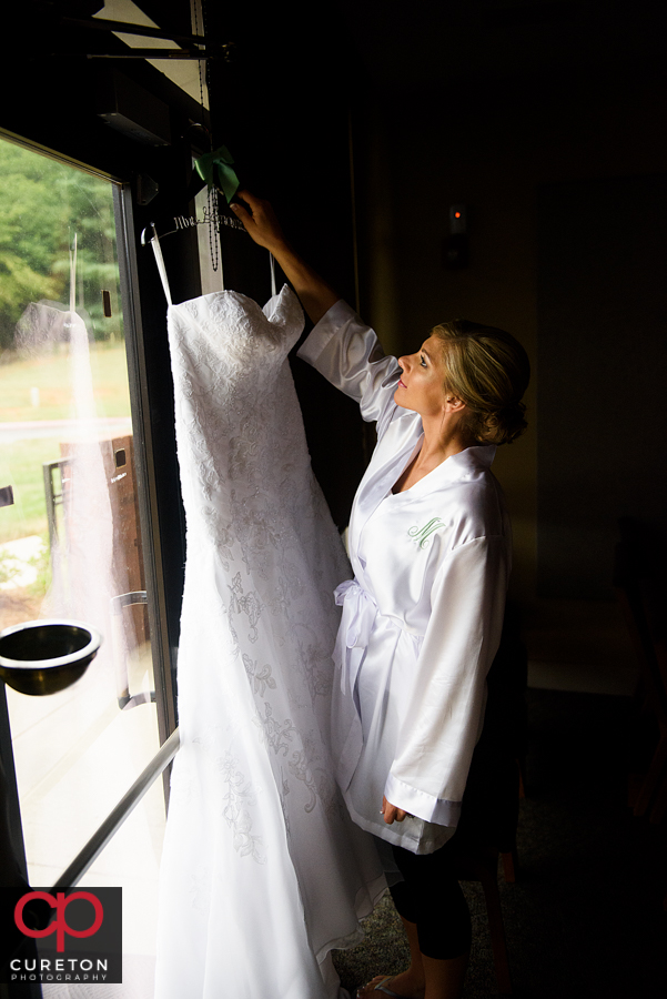 Bride looking at her dress before her wedding.