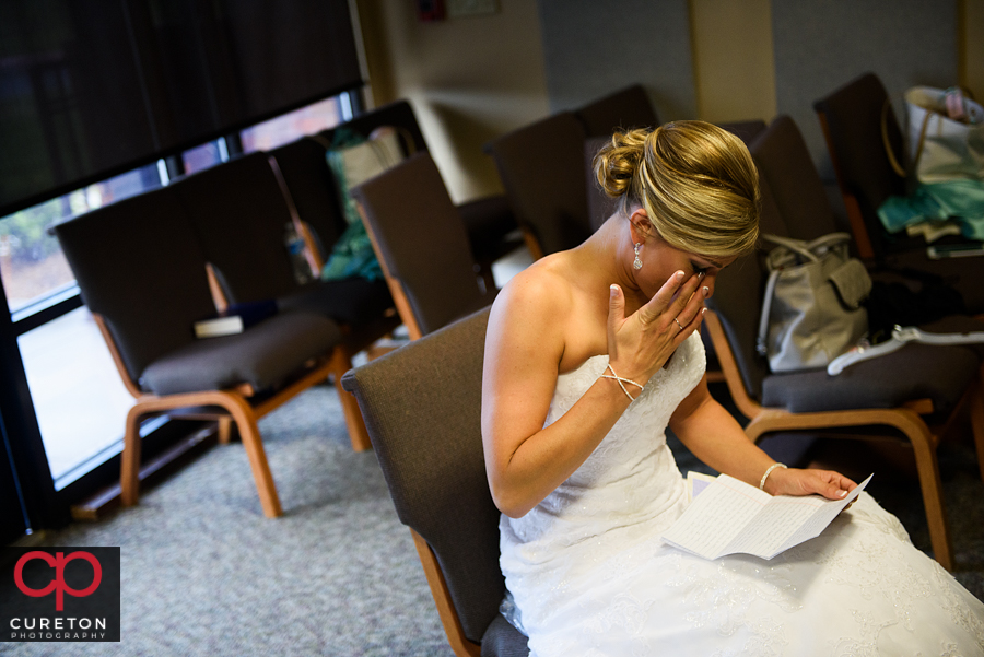 Bride crying while reading a letter from her groom.