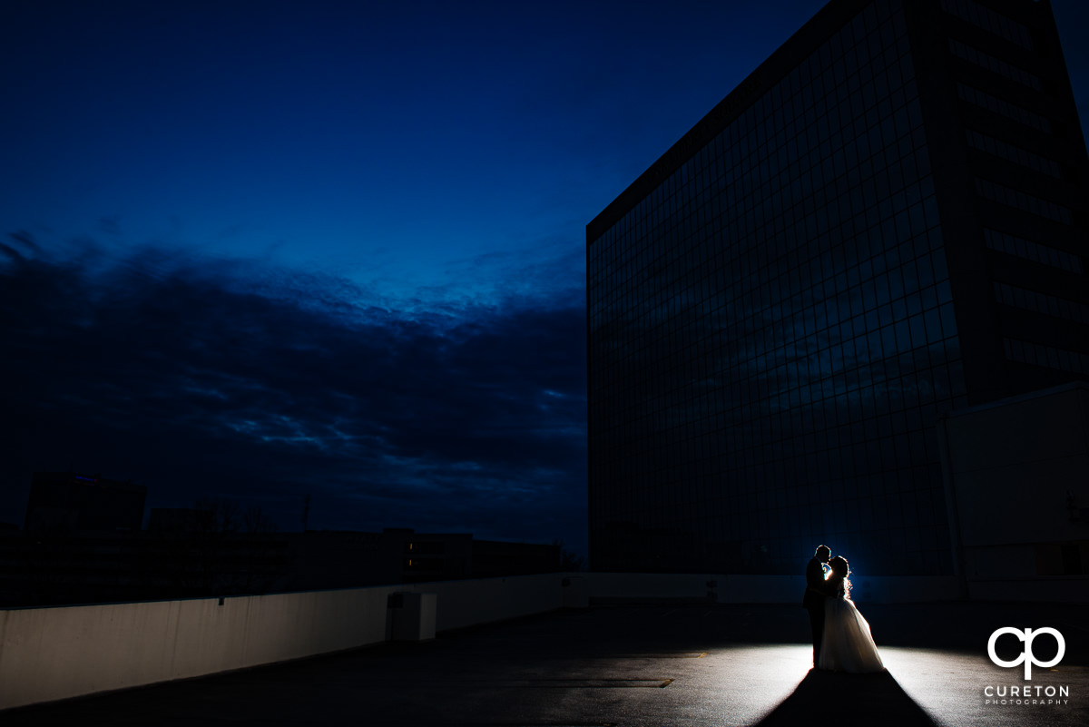 Bride and groom on a rooftop facing an amazing blue hour sky after their wedding at The Commerce Club in Greenville,SC.