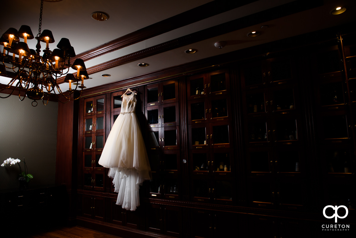 Wedding dress hanging in the wine room at The Commerce Club.