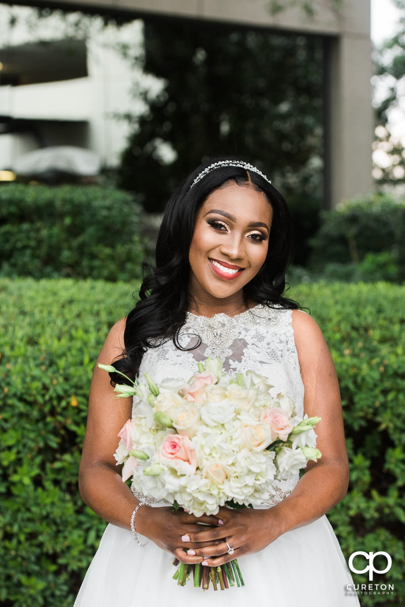 Bride holding her bouquet in front of the Commerce Club.