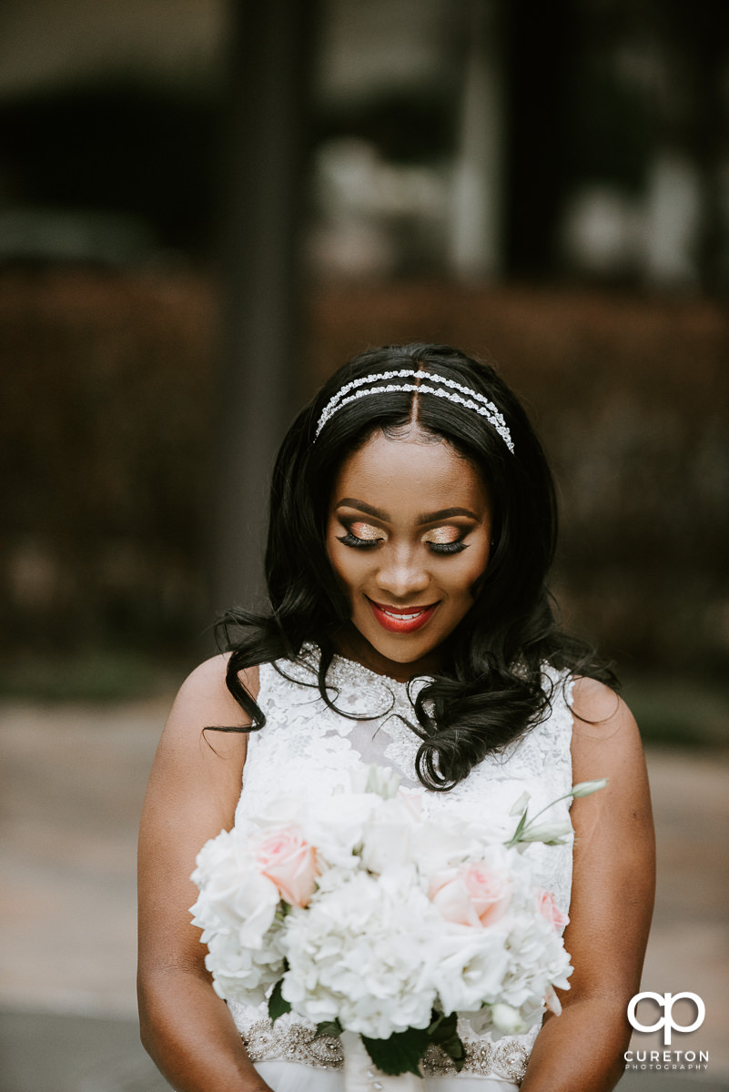 Bride looking at her flowers.