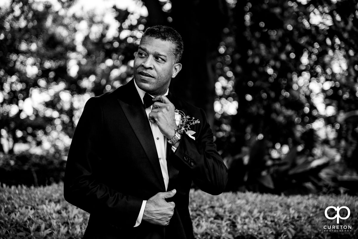 Groom adjusting his tie.