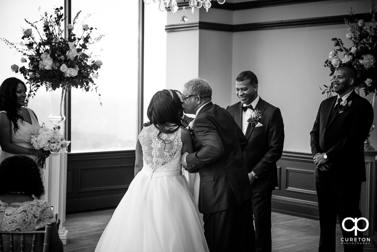 Bride's father giving her away at the ceremony.