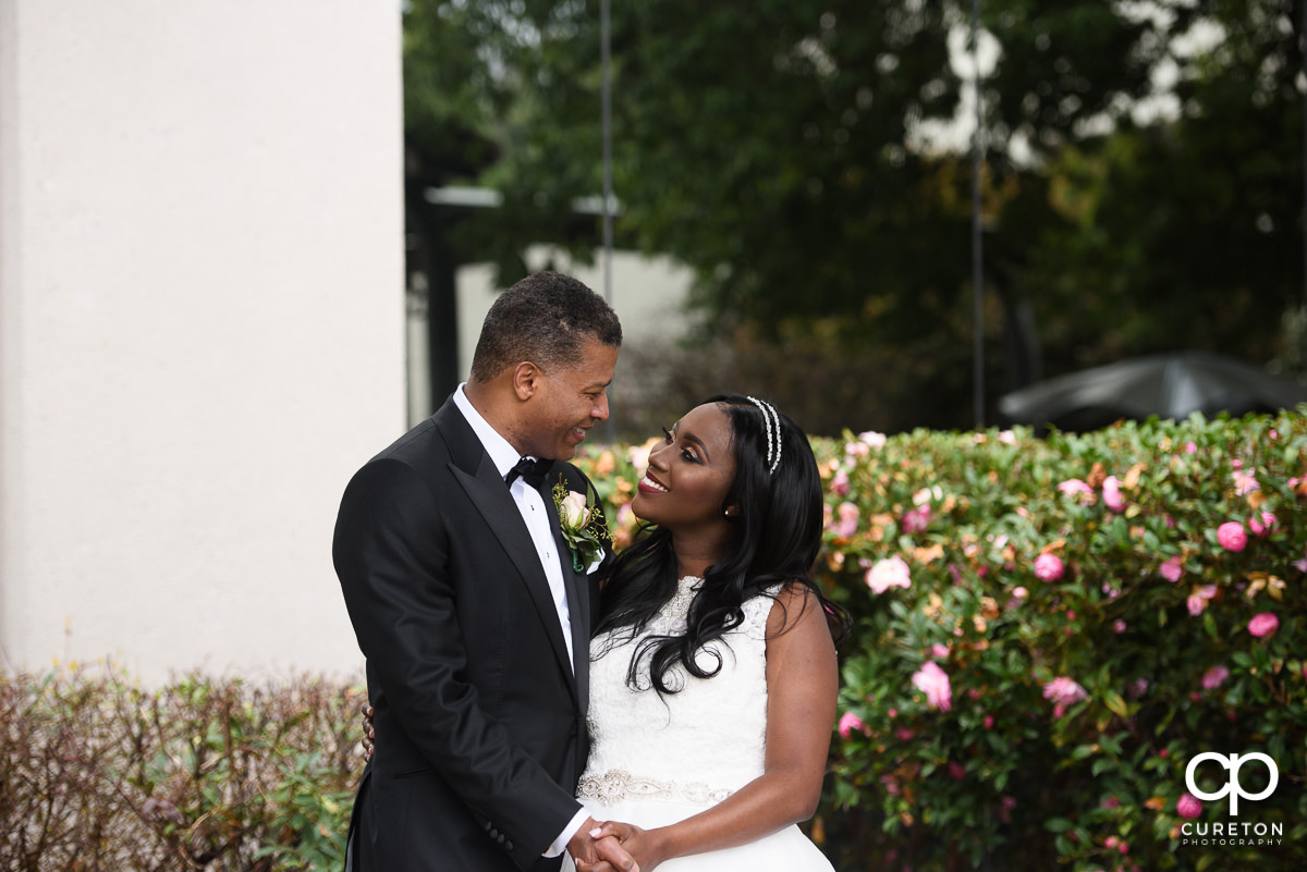 Bride and groom looking at each other with spring flowers in the background.