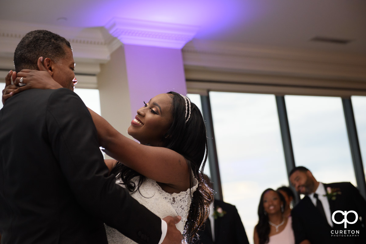 Bride smiling at her groom during their first dance as husband and wife.