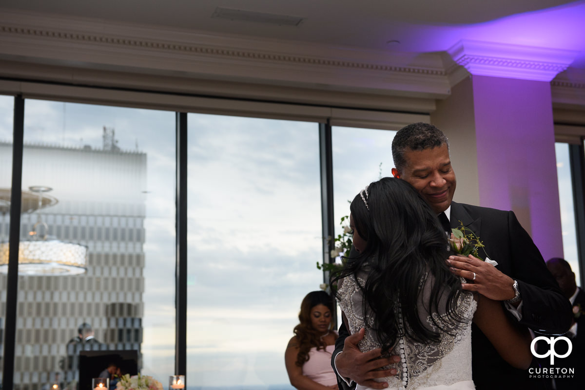 Groom hugging his bride on the dance floor.