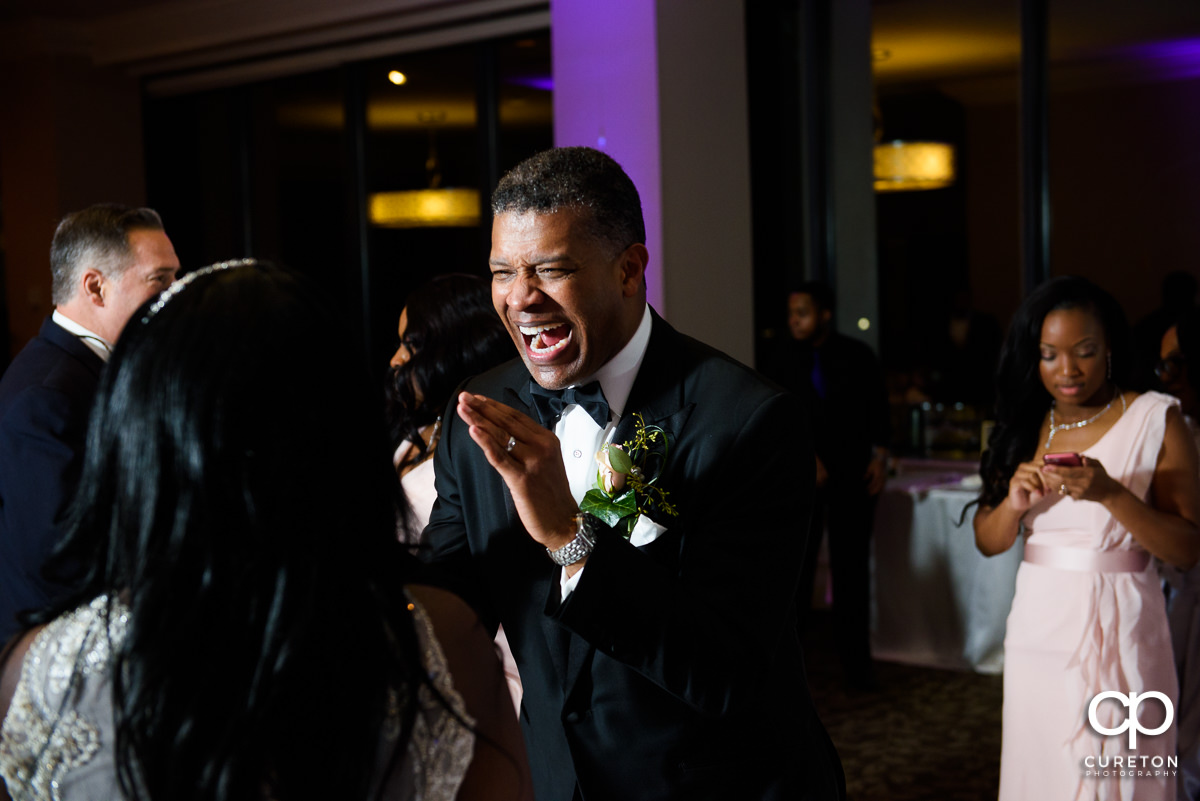 Groom laughing on the dance floor.