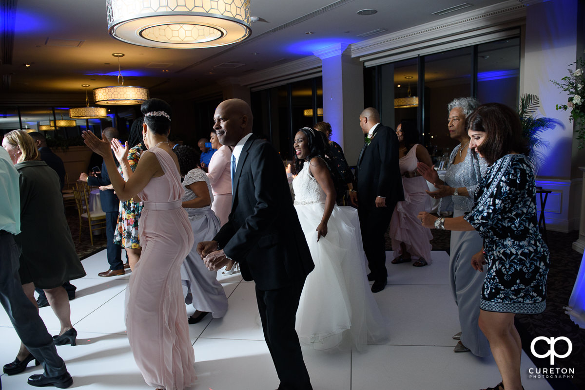 Wedding guests line dancing.