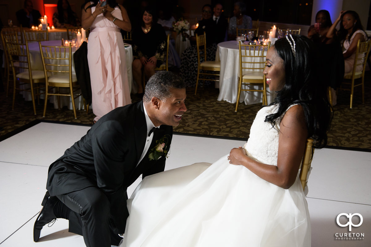 Groom removing the garter.