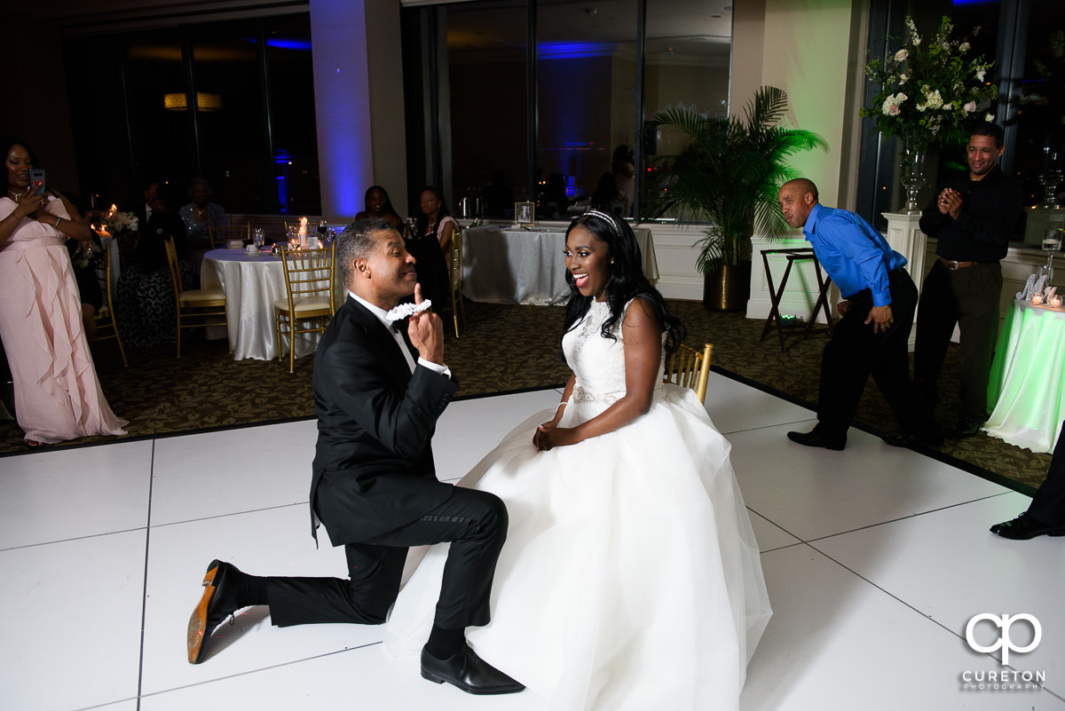 Groom holding up the garter.