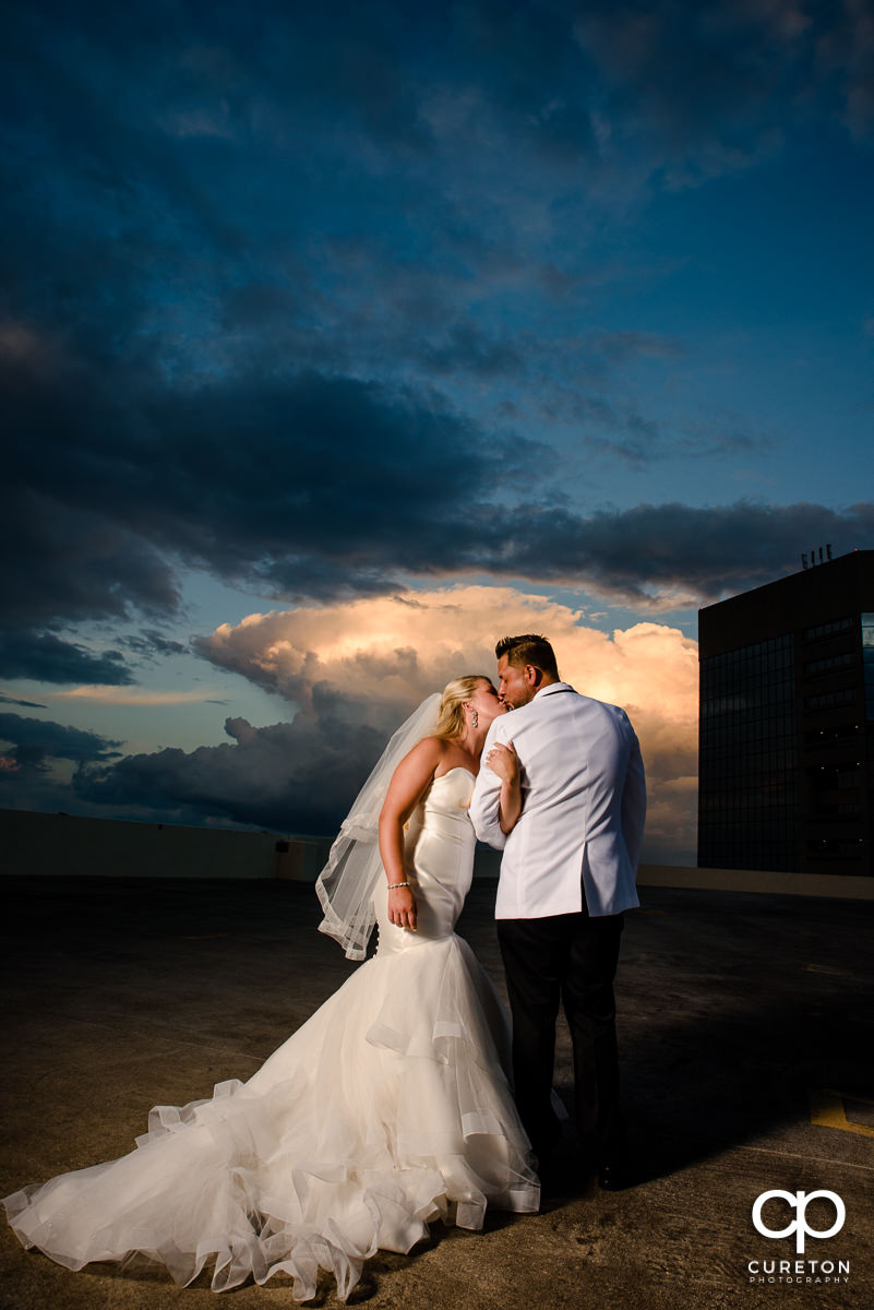 Bride and groom on a downtown Greenville rooftop at sunset during their Commerce Club wedding.