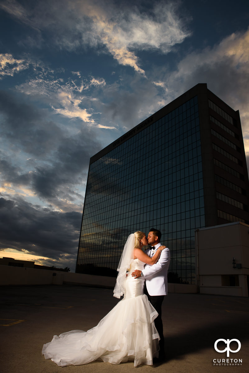 Bride and groom on top of a parking garage at sunset in downtown Greenville,SC.