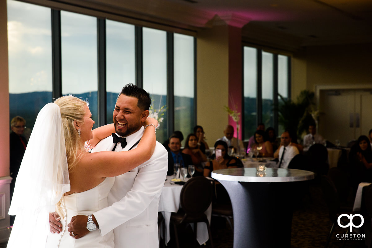 Groom laughing during their first dance at the Commerce Club wedding reception.