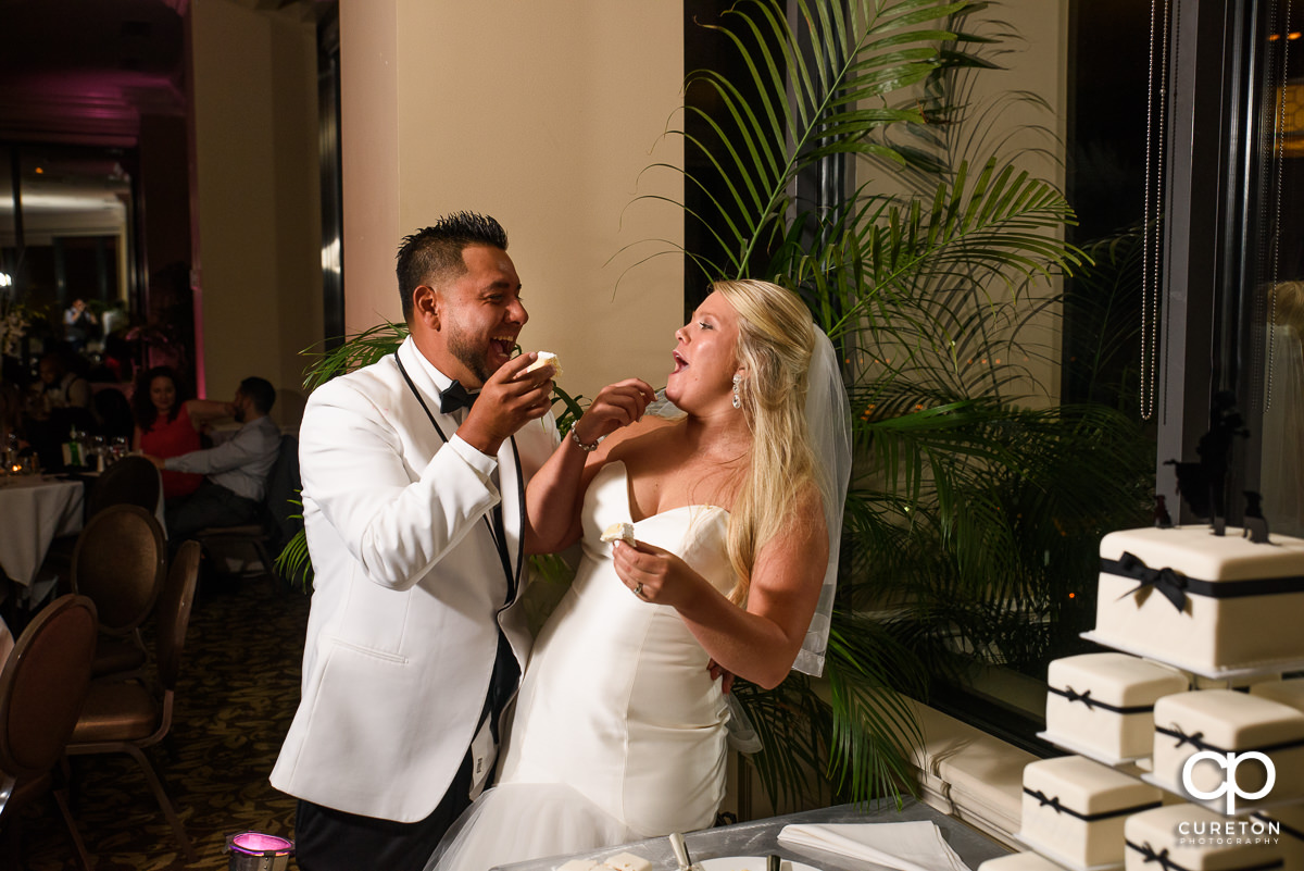Bride and groom feeding each other cake.