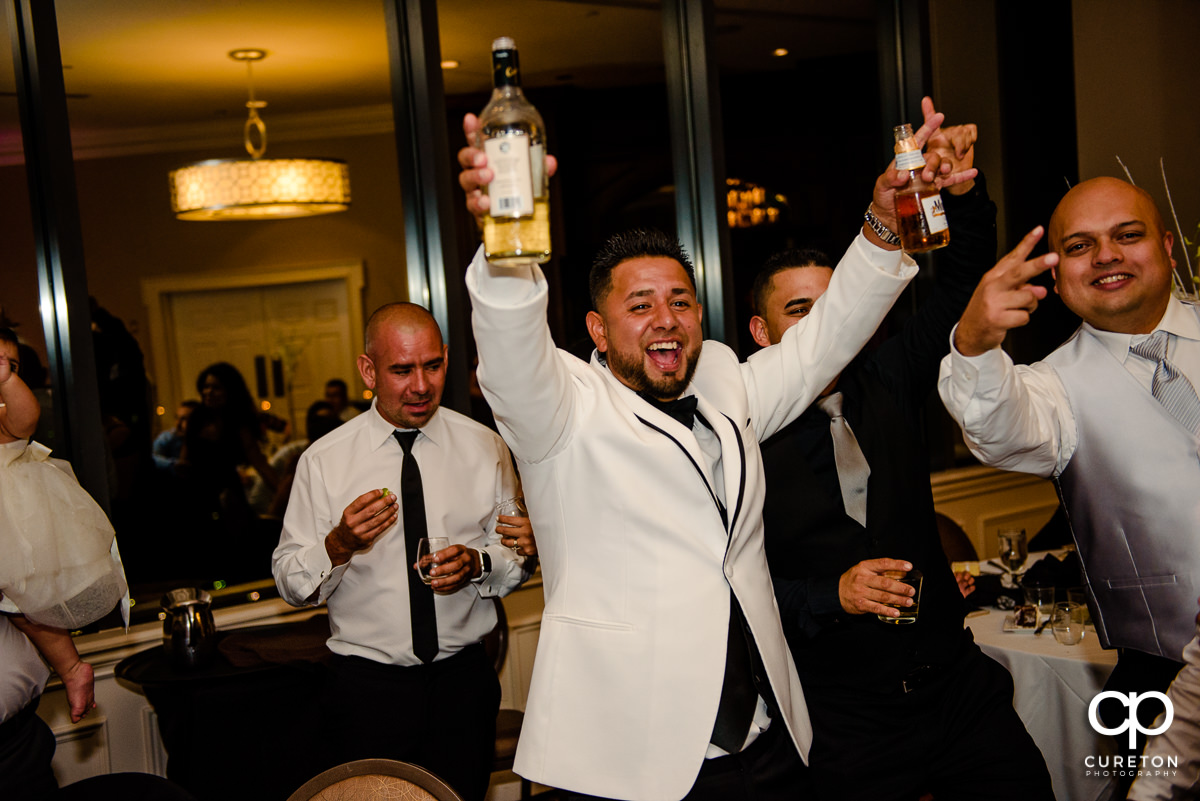 Groom holding a bottle of tequila.