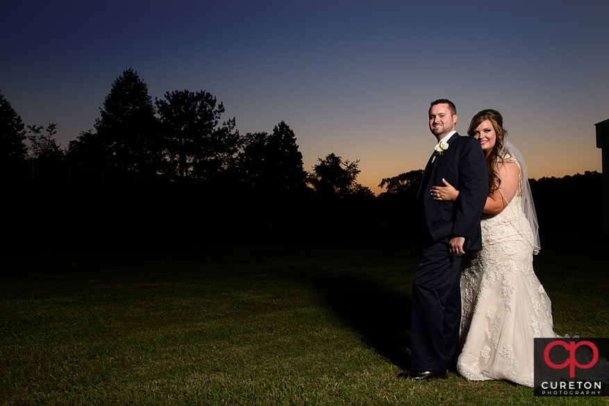 Briding groom cuddling at sunset after their Cowpens SC wedding at Mountain View Baptist..