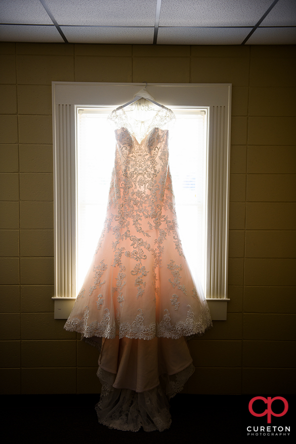 Bridal dress hanging in the window.