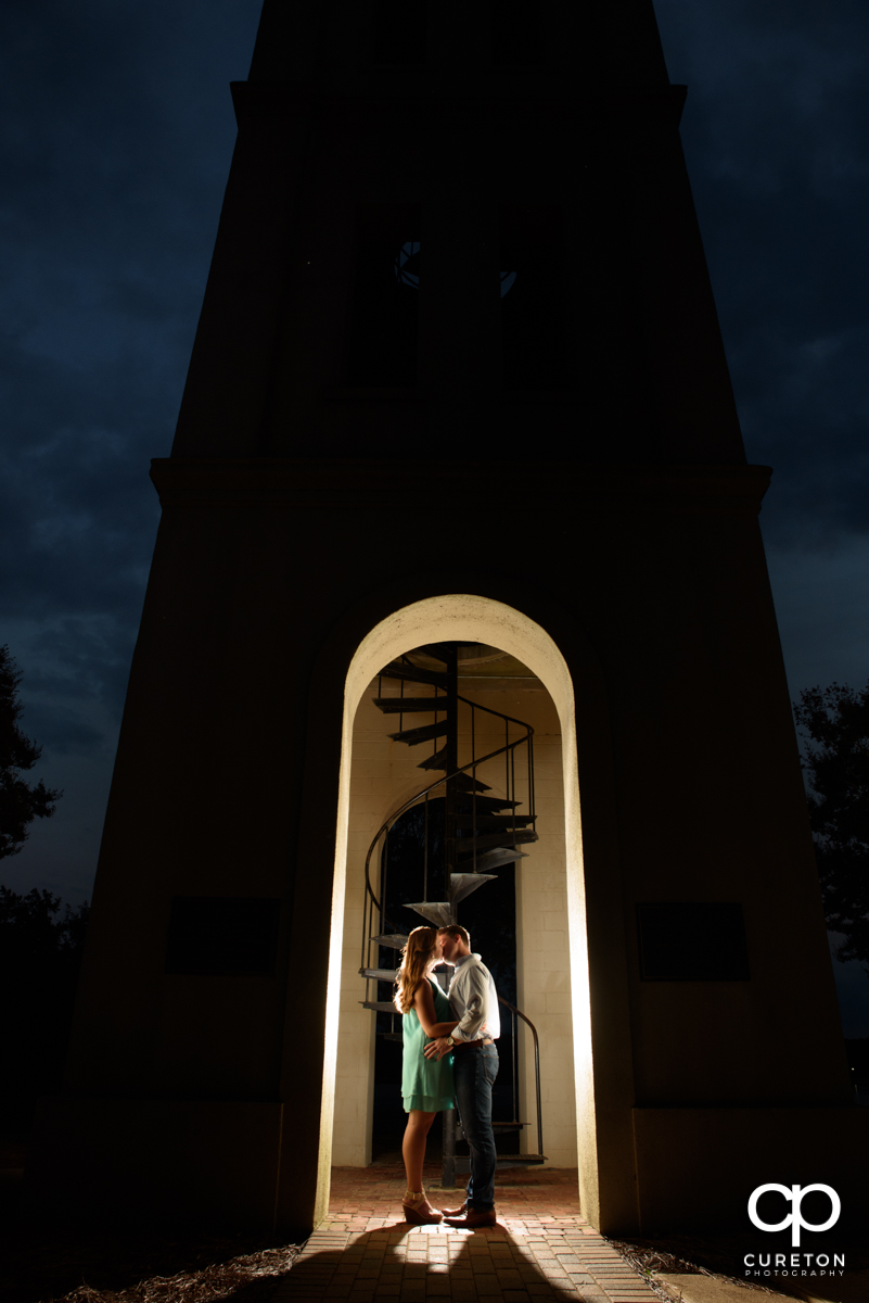 Engaged couple kissing in the Bell Tower at Furman.