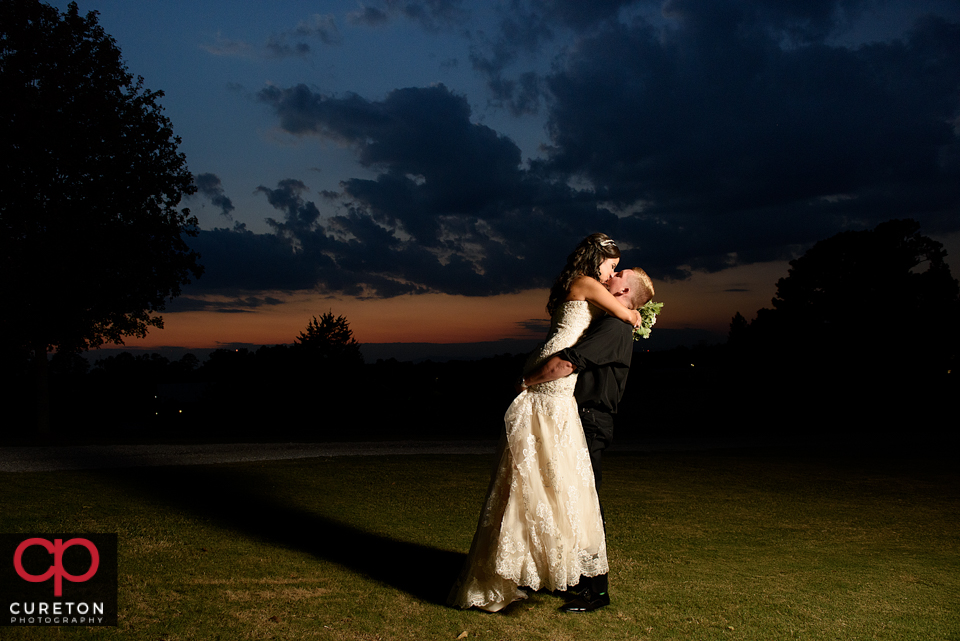 Bride and groom kissing at sunset after their Daniel chapel wedding on the Furman university campus.
