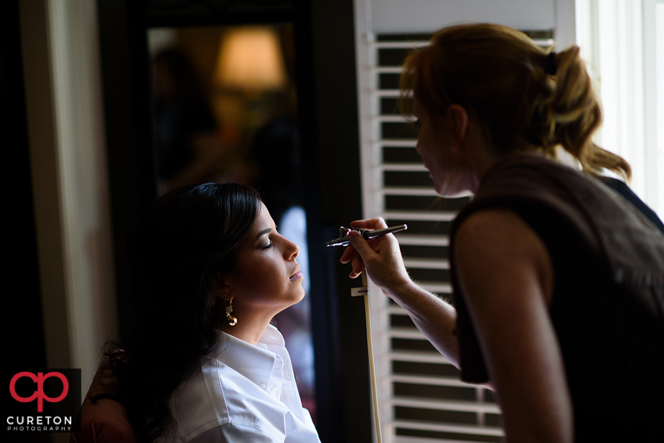 The bride getting airbrush makeup applied.