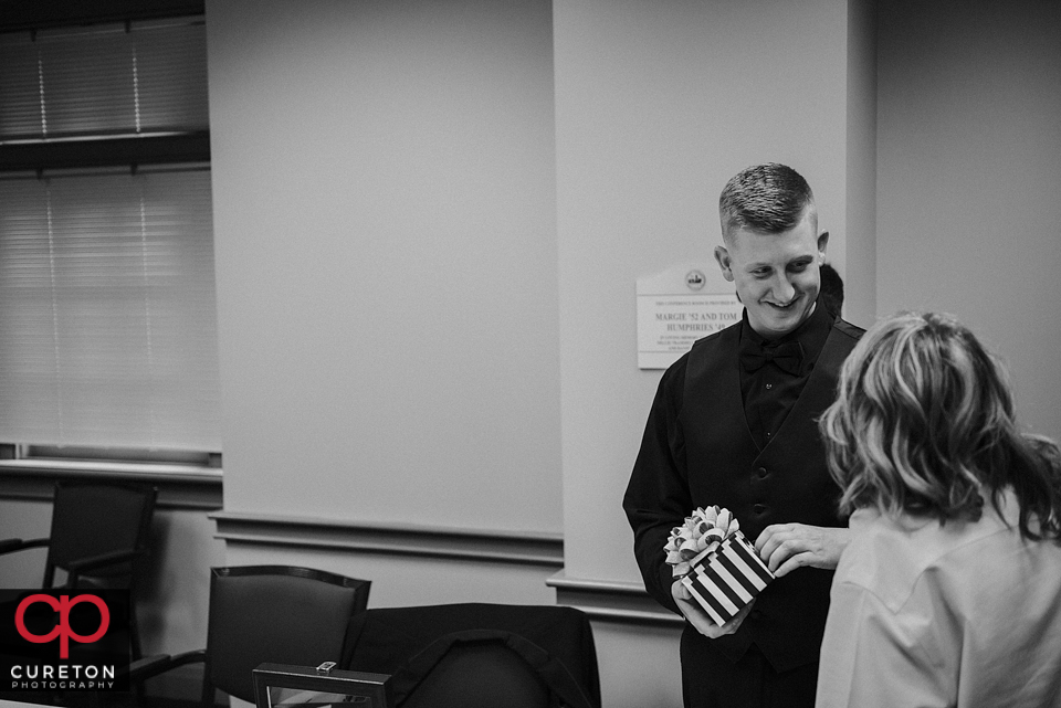 Groom opening his gift from the bride.