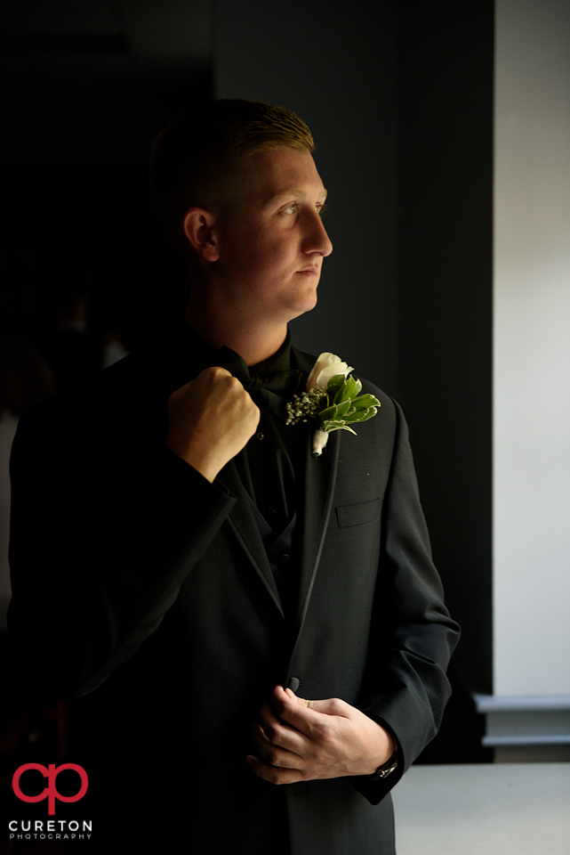 The groom straightening his tie.