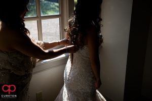 The bride putting on her dress.