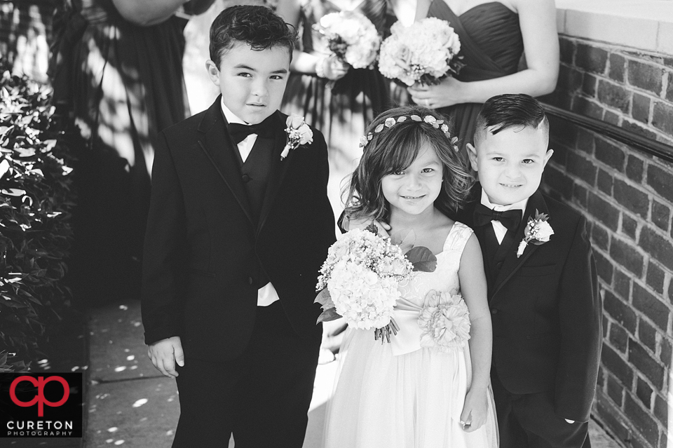 The flower girl standing with the ringbearers outside of Daniel chapel.