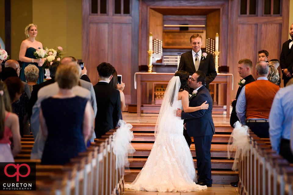 The father of the bride kisses her before the wedding.