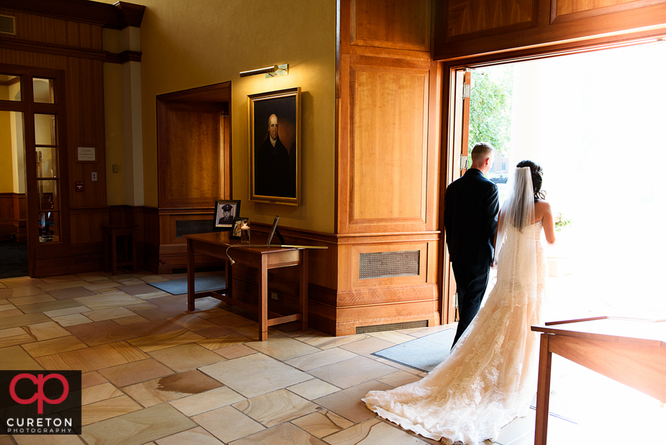 The bride and groom walking out into the sunlight from Daniel chapel.