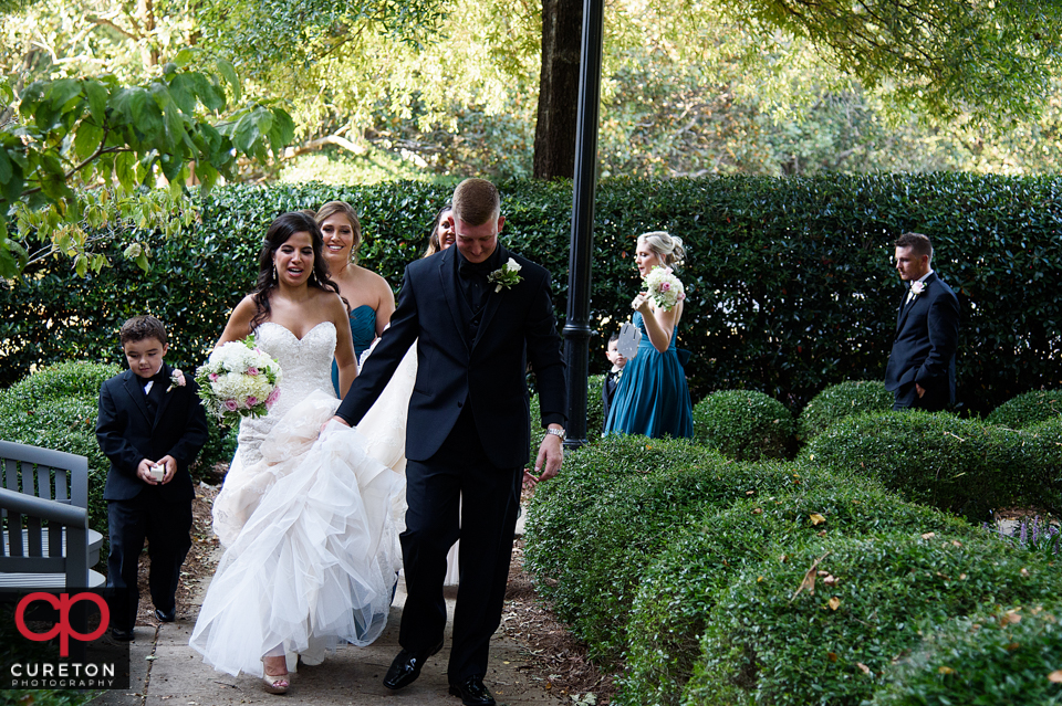 Bride and groom walking with the wedding party.