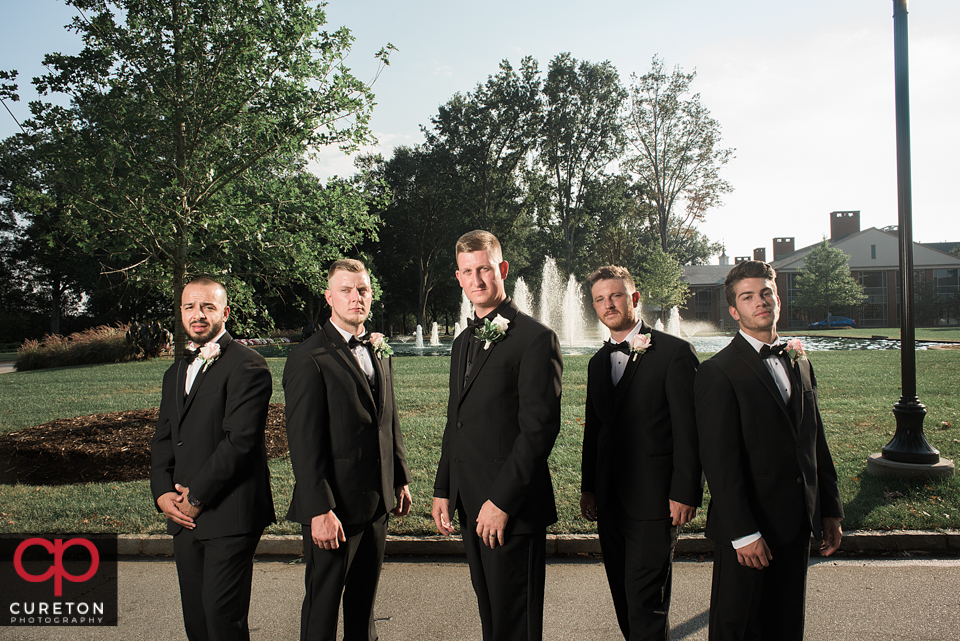 Groomsmen standing in front of the fountain at Furman.