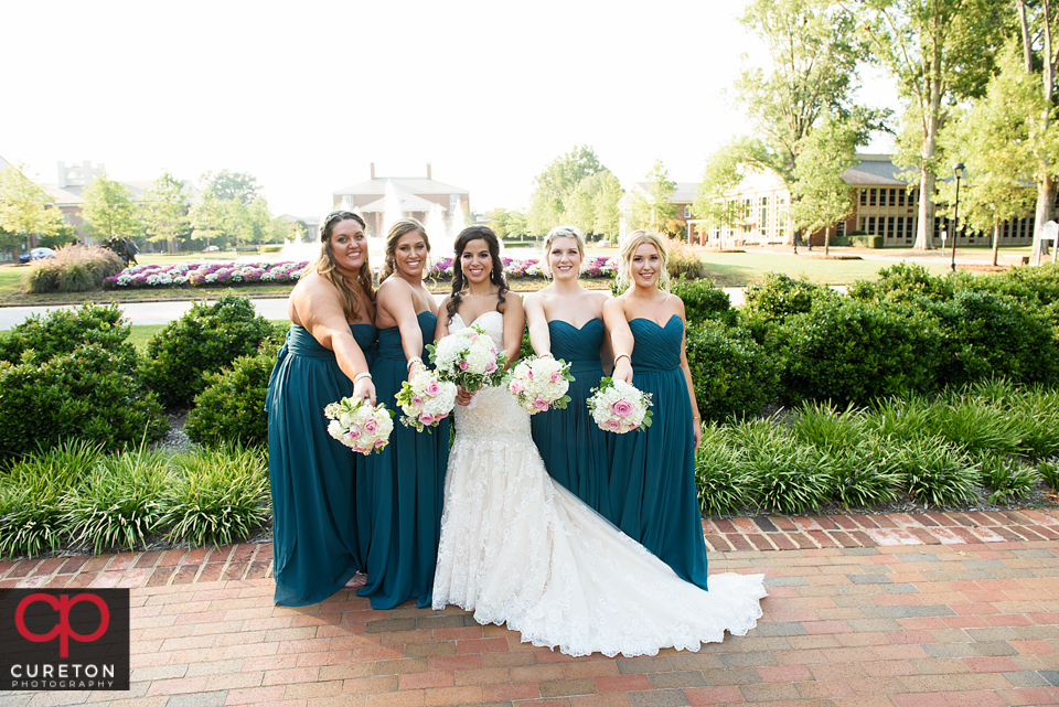 Bridesmaids showing off their flowers outside of Daniel chapel.
